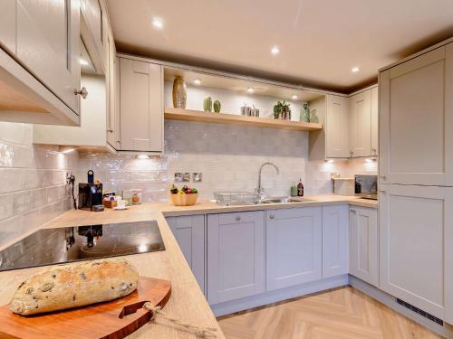 a kitchen with white cabinets and a wooden counter top at 1 bed in Ilkley 87569 in Ilkley