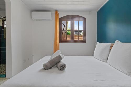une chambre avec un lit blanc avec une fenêtre dans l'établissement Villa Diamantina, au Diamant