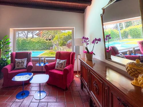 a living room with two chairs and a mirror at Villa Etna in San Giovanni la Punta