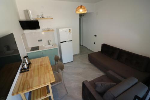 a living room with a couch and a table at Paradise Garden Apartments in Gumusluk