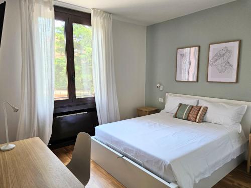 a bedroom with a white bed and a window at LuMI Apartment in Basiglio