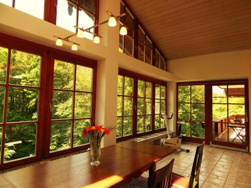 a large dining room with a table and large windows at Hotel Königsseer Hof in Schönau am Königssee