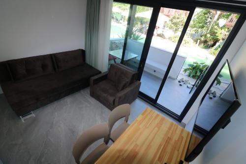 a living room with a couch and a wooden table at Paradise Garden Apartments in Gumusluk
