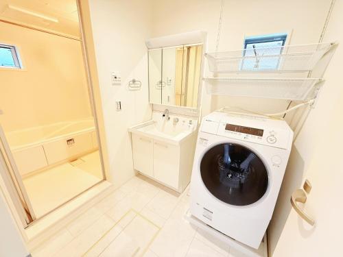 a white washing machine in a bathroom with a sink at 吉屋2号館 in Tokyo