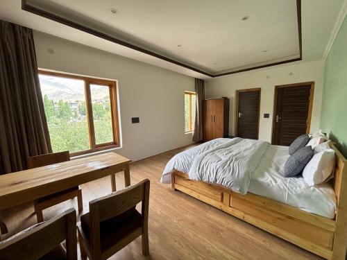 a bedroom with a bed and a table and a window at Skyline Homestay in Leh