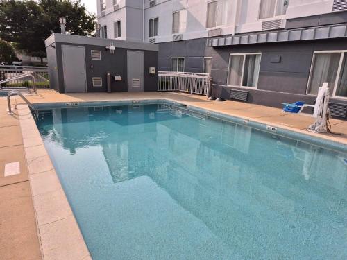 a large blue swimming pool in front of a building at Spark by Hilton Lancaster in Lancaster