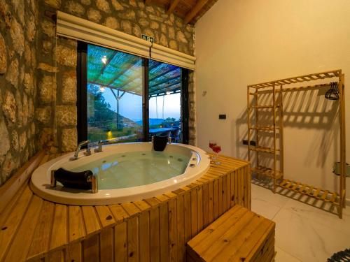 a large bath tub in a room with a window at VillaVista07 in Kaş