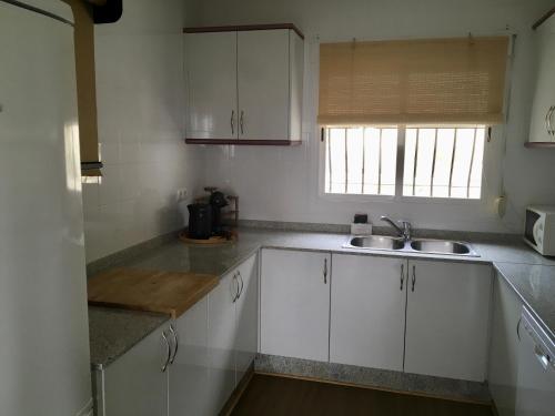 ハロンにあるVilla Almazaraの白いキャビネット、シンク、窓付きのキッチン