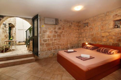 um quarto com uma cama e uma parede de pedra em Apartments Caralipeo em Makarska