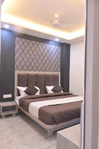 a bedroom with a large bed with a large headboard at hotel k stay by Anmol in Haridwār
