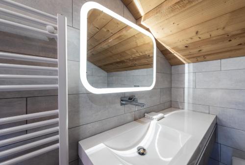 a bathroom with a white sink and a mirror at Le chalet de Nicolas - Your Nature Exclusive Retreat ! in Le Tholy