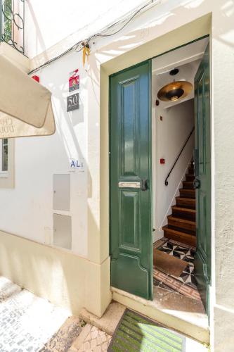 a green door on the side of a building with stairs at Solar das Termas in Caldas da Rainha