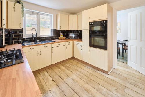 a kitchen with white cabinets and a stove top oven at Host & Stay - Blueberry House in Launceston