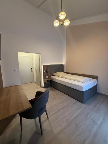 a bedroom with a bed and a table and a chair at Zur Post Wellness und Sporthotel in Tännesberg