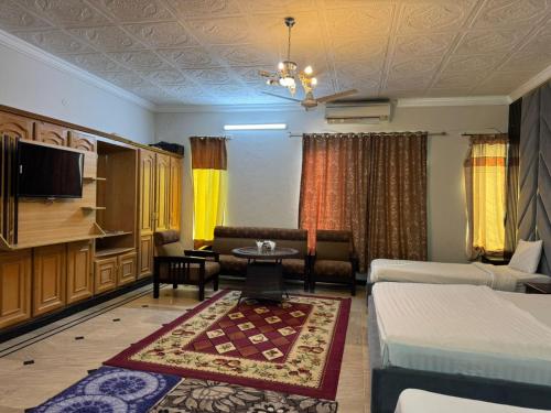 a living room with a bed and a couch at Arizona Lodge Guesthouse in Islamabad