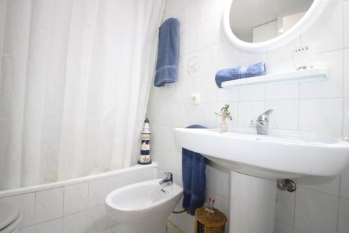 een witte badkamer met een wastafel en een toilet bij Casa Sol in Son Parc