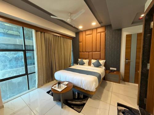 a bedroom with a bed and a large window at hotel avenue gold in Koba