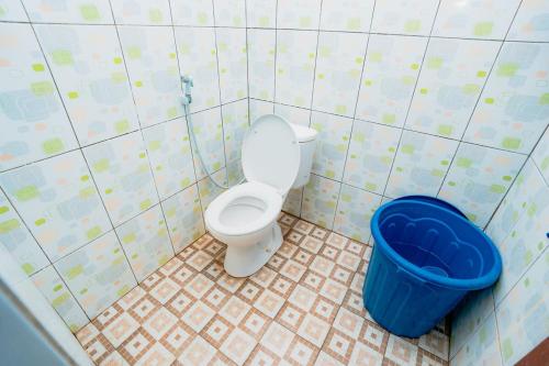 a bathroom with a toilet and a blue bucket at Guesthouse Andalusia Gontor 1 Ponorogo in Ponorogo