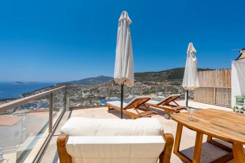 un balcone con mobili bianchi e vista sull'oceano di Luxury Two Bedroom Seaview Villa in Kalkan a Kaş