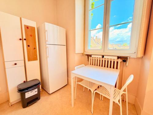 a kitchen with a table and two chairs and a window at Appartement 4 prsn Parking Proche Citadelle in Besançon