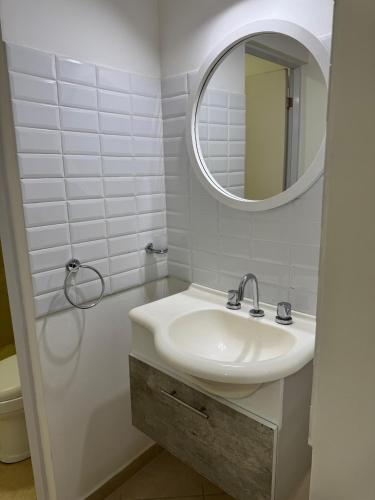 a white bathroom with a sink and a mirror at Don Antonio Apart 4 in Resistencia