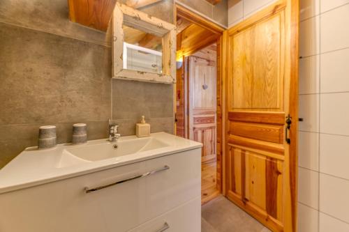 a bathroom with a sink and a wooden door at Chalet Mariouchka in Villard-Reculas