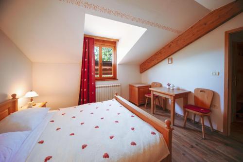 a bedroom with a bed and a table and a window at Green Escape garni hotel in Postojna