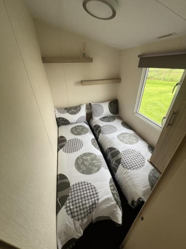 two beds in a small room with a window at The Salsa at StrathavonRentals in Girvan