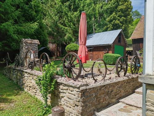 a stone retaining wall with a red umbrella and wheels at Chalupa Dubková in Lazy pod Makytou