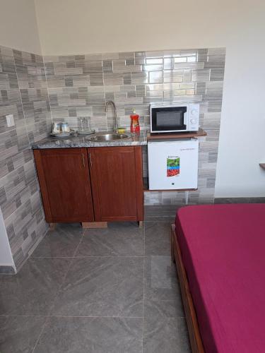 a small kitchen with a sink and a microwave at Mirage in Tarrafal