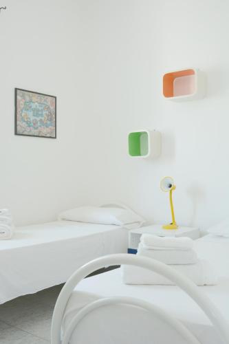 a white room with two beds and a table at AP Apartment - Baia Verde in Baia Verde