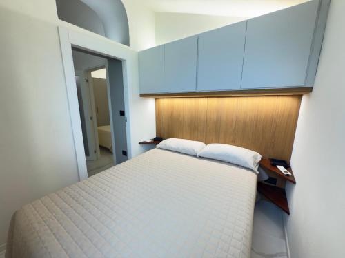 a bedroom with a white bed and blue cabinets at Luxury and Exclusivity on the Seafront in Alassio in Alassio