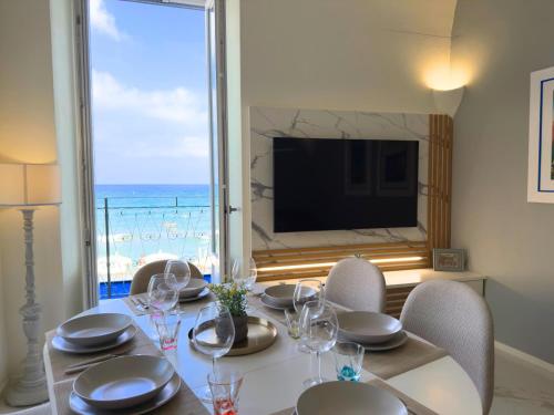 a dining room with a table and a view of the ocean at Luxury and Exclusivity on the Seafront in Alassio in Alassio