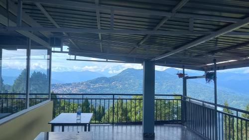 a balcony with a table and a view of mountains at Ramailo Resturant and Homestay in Kalimpong