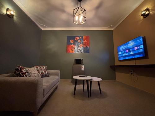 a living room with a couch and a tv at Bukoto Ntinda 1 bedroom in Nalakonge