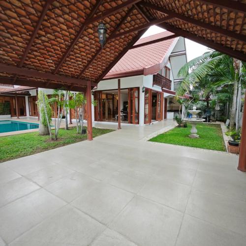 une vue extérieure d'une maison avec patio et piscine dans l'établissement Baan thai pool villa pattaya, à Jomtien Beach