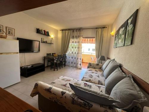 a living room with a couch and a kitchen with a table at Los Angeles in Los Cristianos