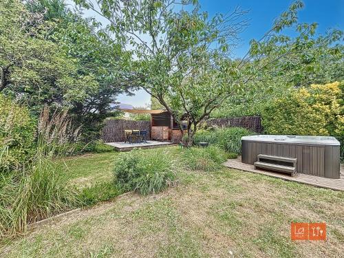 a backyard with a hot tub and a tree at L'ensoleillée - Proximité plage in Wimereux