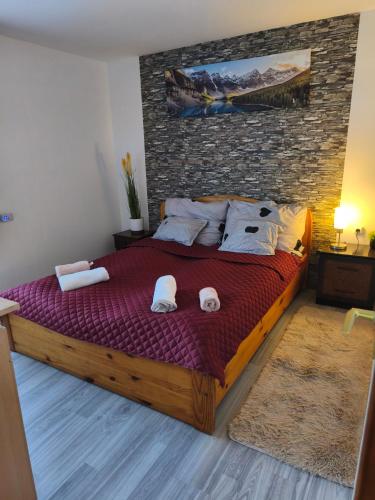 a bedroom with a large bed with towels on it at Furó Vendégház 2 in Fülöp