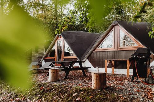 a tiny house with a black roof at Chambre avec jacuzzi ou Chalets dans les bois in Gesves