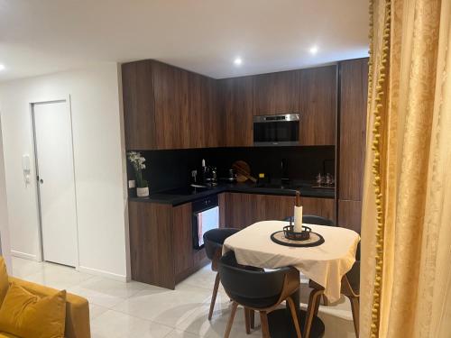 une cuisine avec une table et des chaises et une cuisine avec un four micro-ondes dans l'établissement Deux. Pièces face à la scène., à Neuilly-sur-Seine