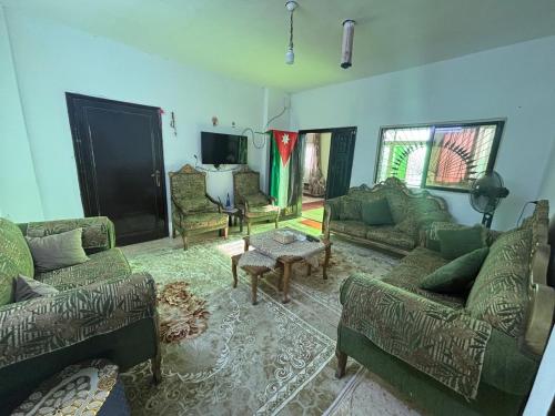 a large living room with couches and a tv at Leith Holiday Home in ‘Ayn Jannā