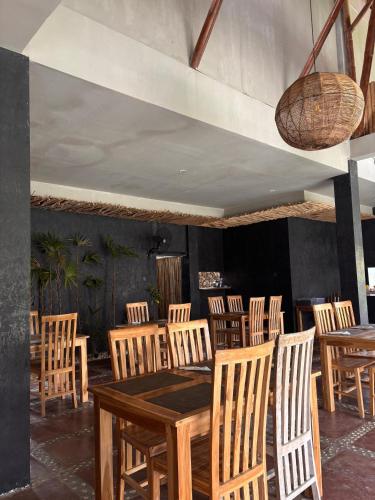 a dining room with wooden tables and chairs at Nativo Lombok Hotel in Kuta Lombok