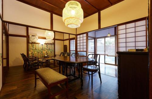 a dining room with a table and chairs and a chandelier at Lotus House Kamakura in Kamakura