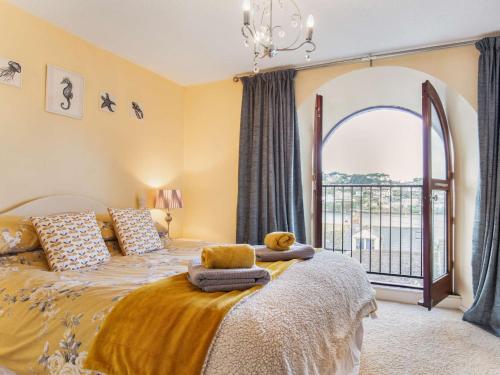 a bedroom with a bed with a large window at 2 Bed in Polruan 75740 in Polruan