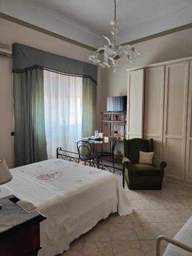 a bedroom with a bed and a chair and a table at B&B Betania in Riposto