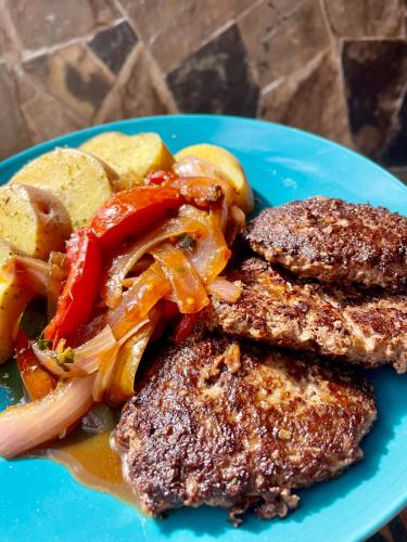 a blue plate of food with meat and vegetables at La Casa de Mario - Gocta in Cocachimba