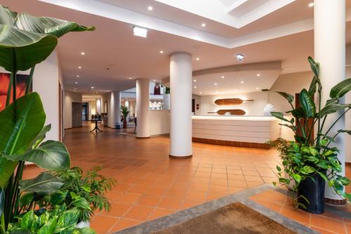 a lobby with plants and a kitchen in the background at Pestana Ocean Bay Resort in Funchal