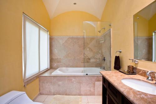 a bathroom with a tub and a shower and a sink at Matapalo Diria #504 Amazing Condo-Ocean View in Tamarindo