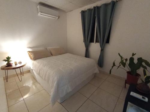 a bedroom with a bed and a table and a window at Copey house Chiriquí, vía hacia Volcán in La Concepción